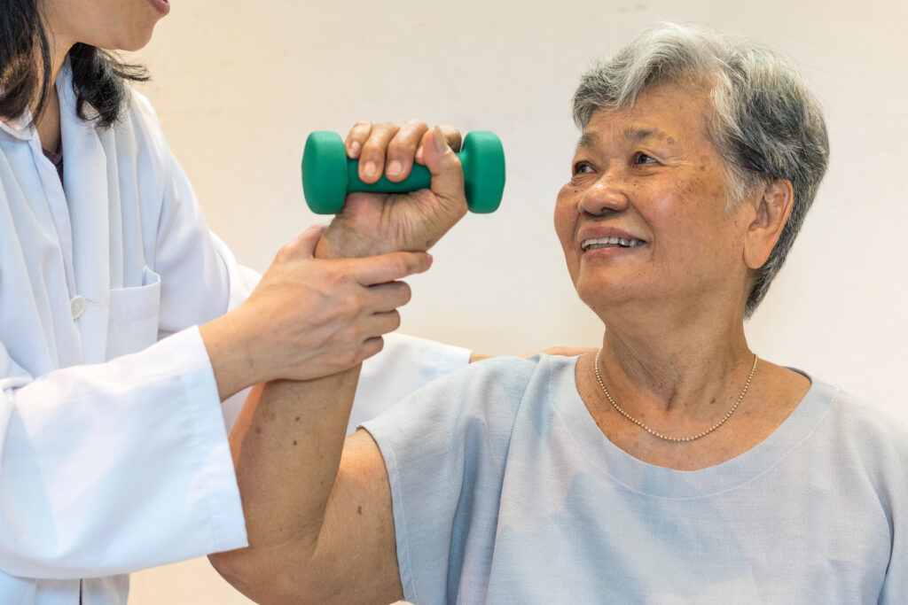 A woman lifting a weight with the help of her physician